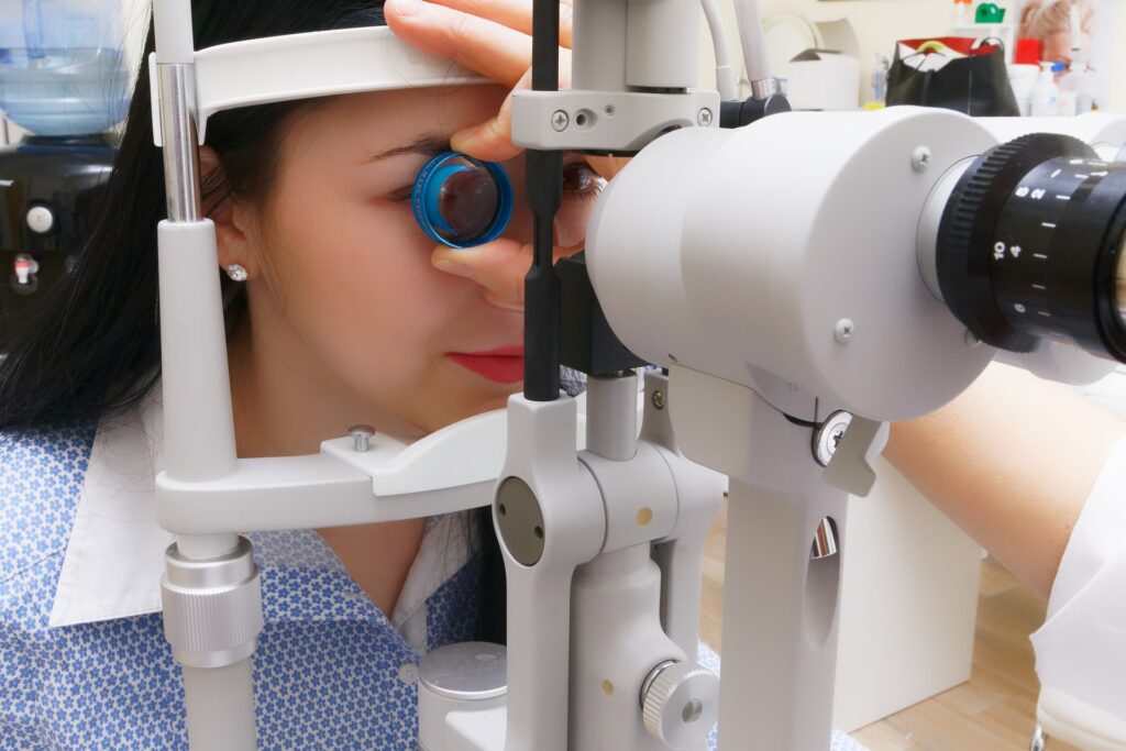 woman is getting her eye check-up through an optical apparatus. 