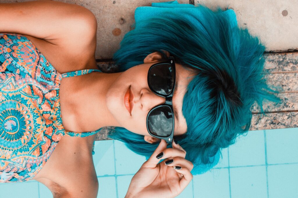 A girl at the poolside flaunting her sunglasses