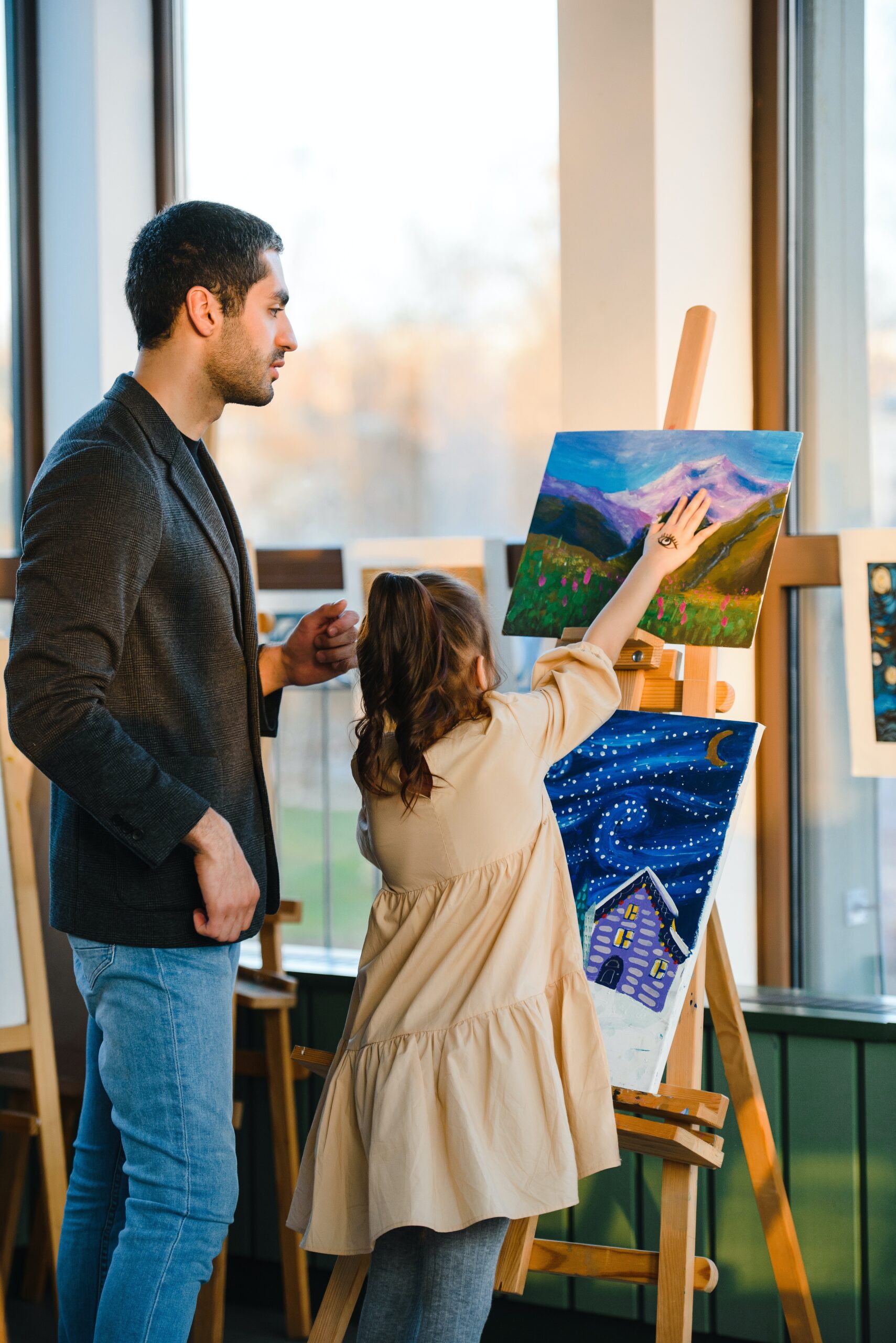 A teacher looking over a child’s painting image