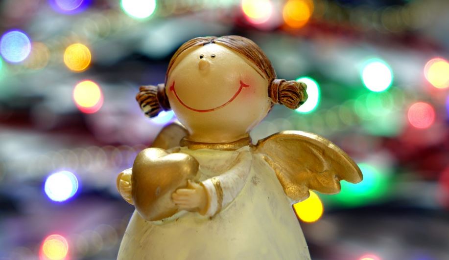 A angel figurine with lights in the background