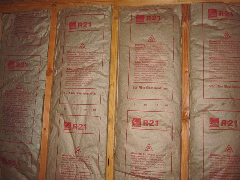 Installed faced fiberglass batt insulation with its R-value visible (R-21) image