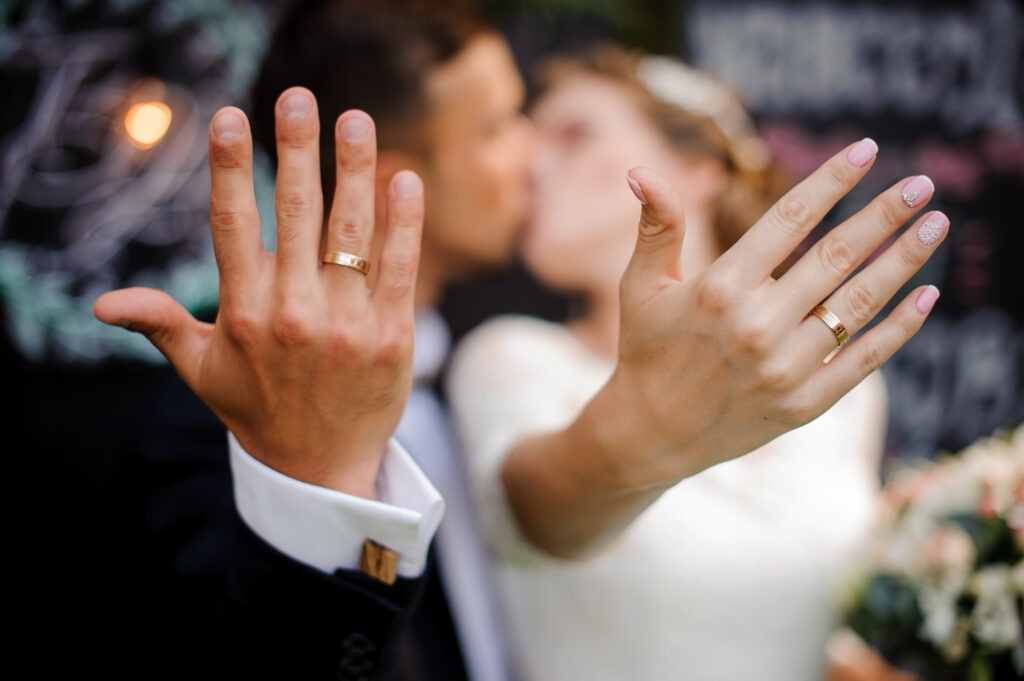 bridegroom-and-bride-kissing-and-showing-wedding-rings image