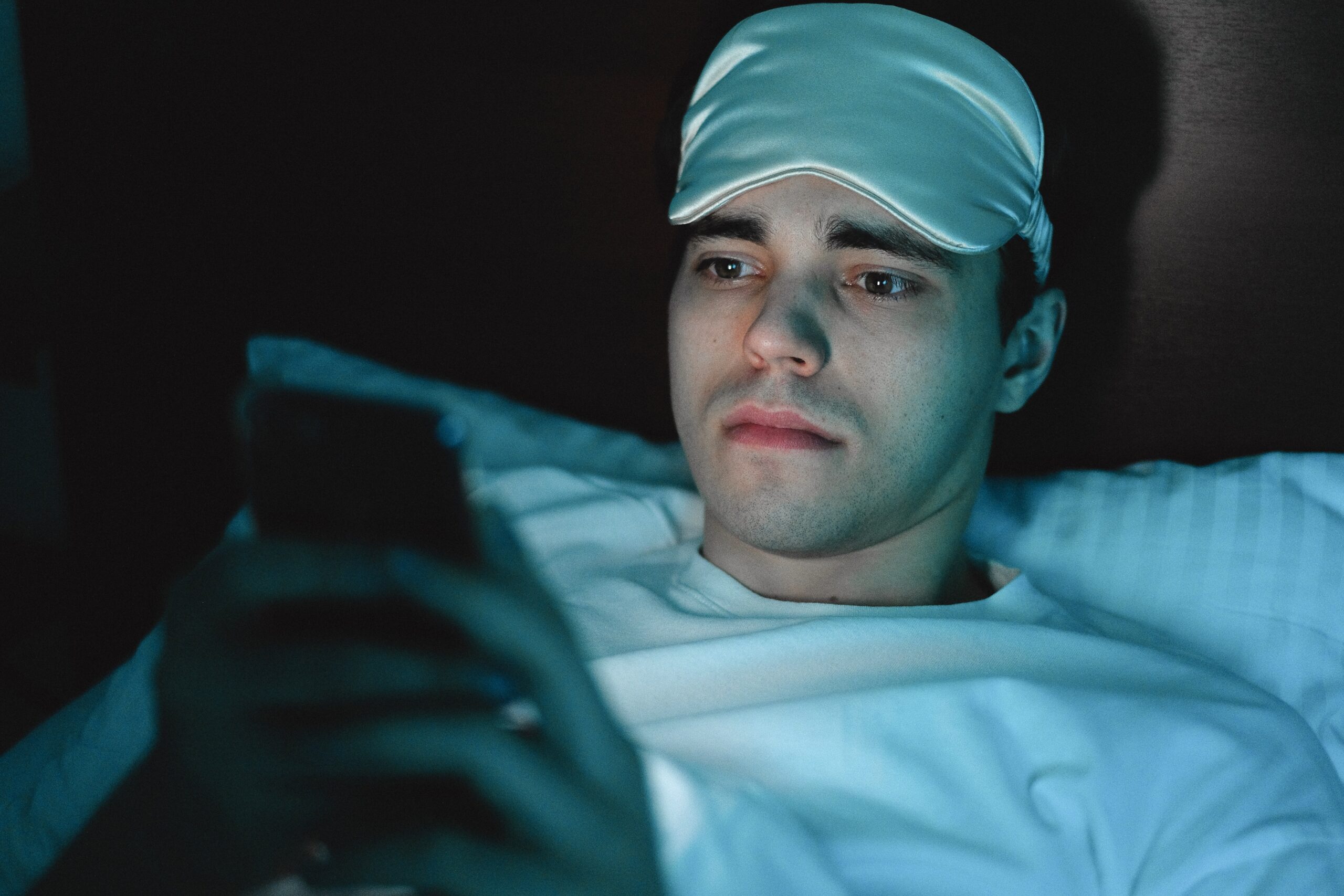 A man using his phone in bed