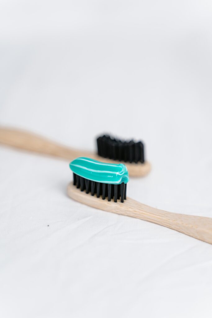 Wooden toothbrush with black bristles and toothpaste image
