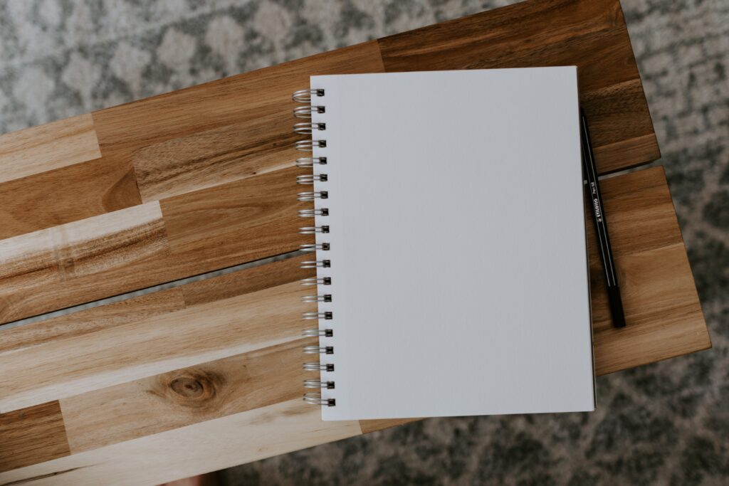 a white notebook and a pen image