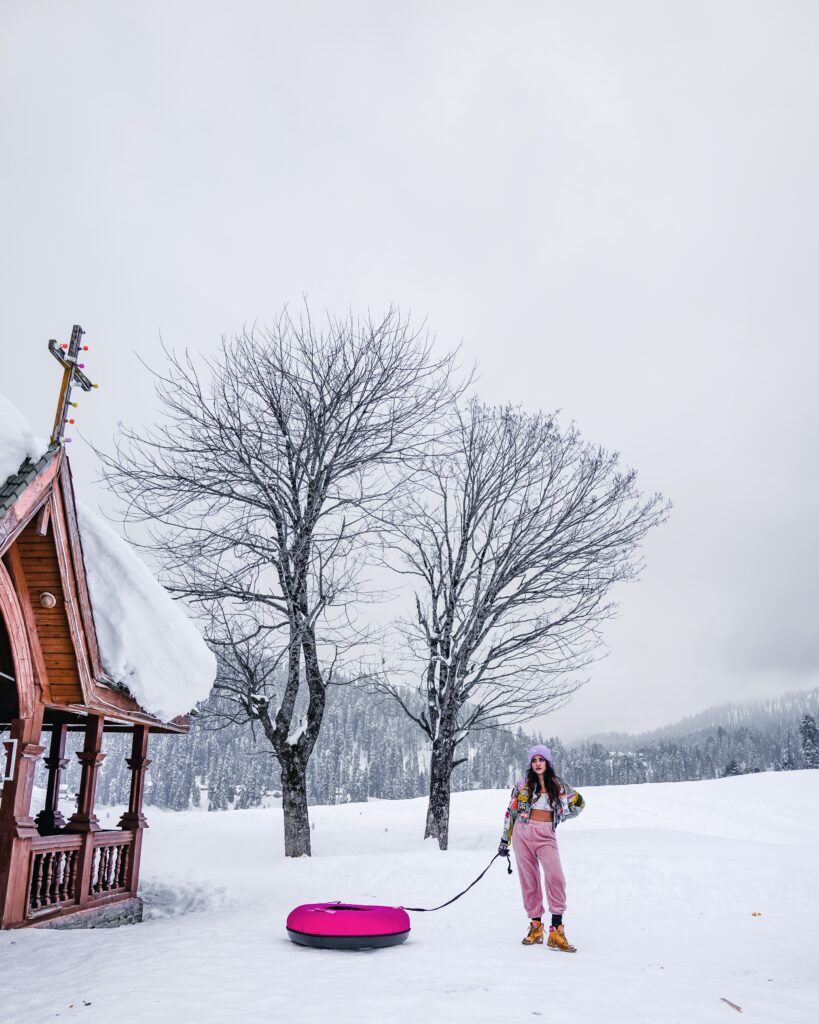 woman holding sled while standing on snow image