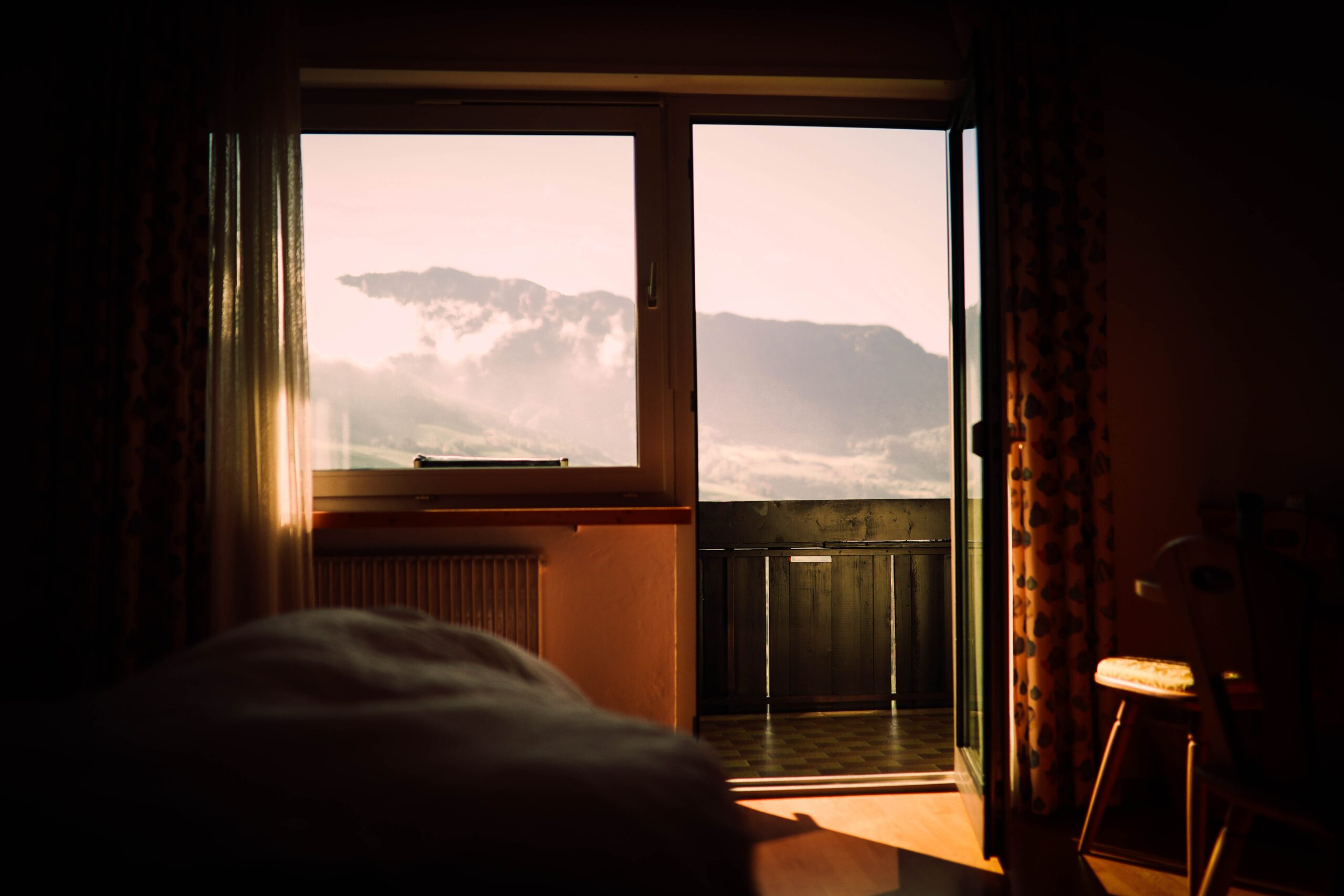 An Image of A room with a mountain view and sunlight seeping in