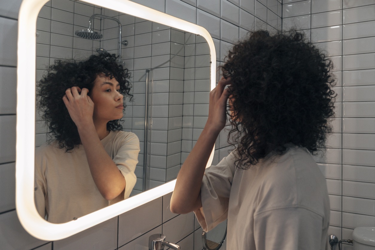 woman-in-in-a-backlit-bathroom-mirror