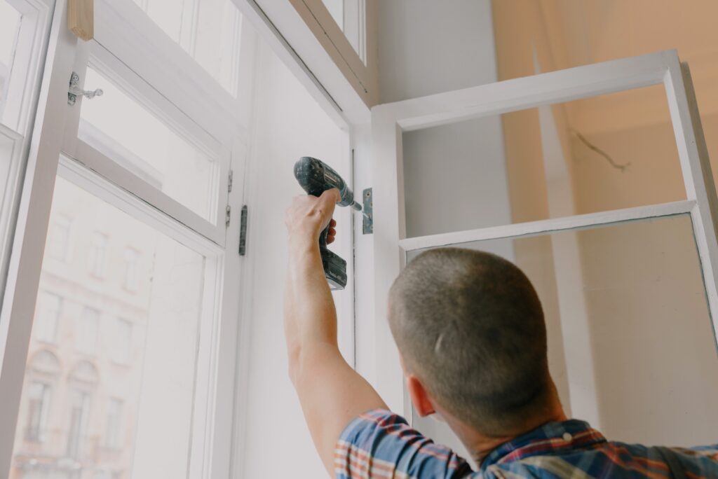 man installing window in room image
