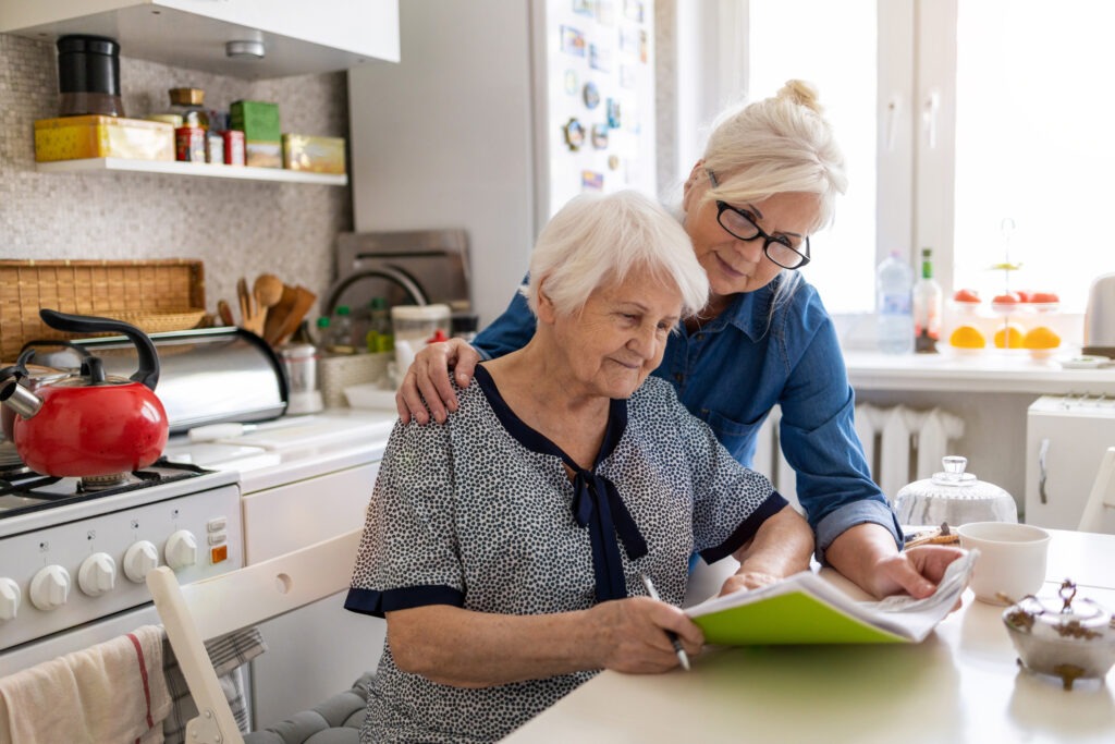 mature-woman-helping-elderly-mother-with-paperwork image