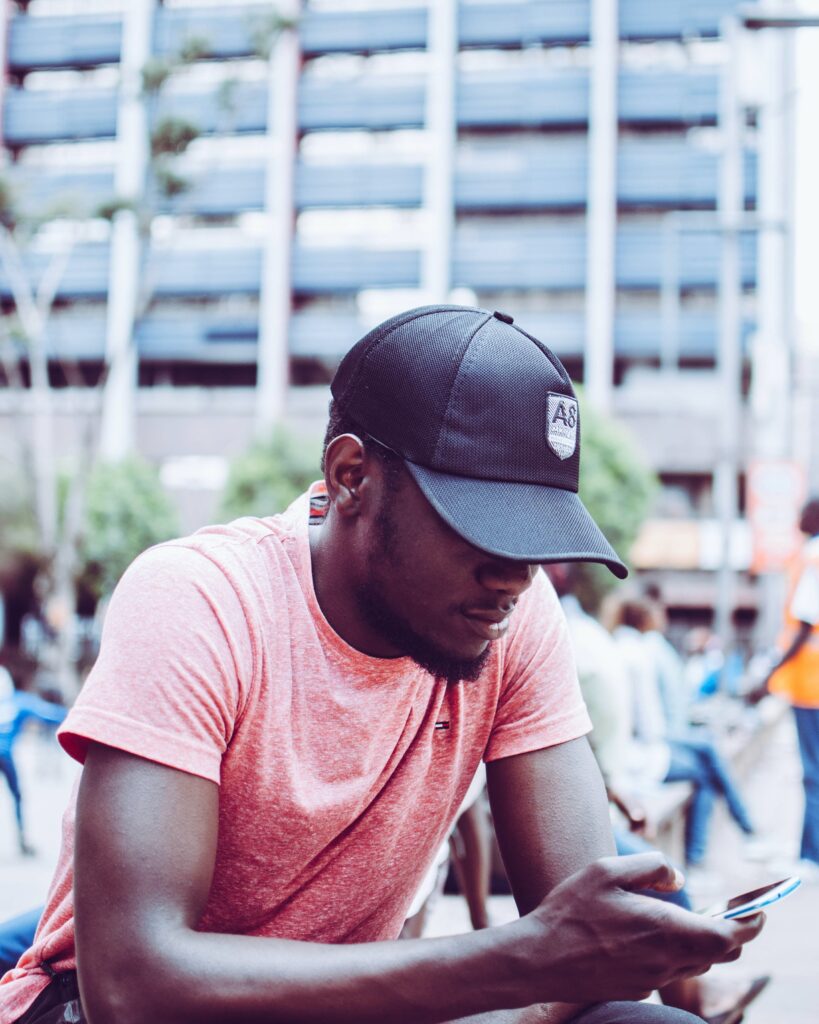 A man wearing a cap on his phone