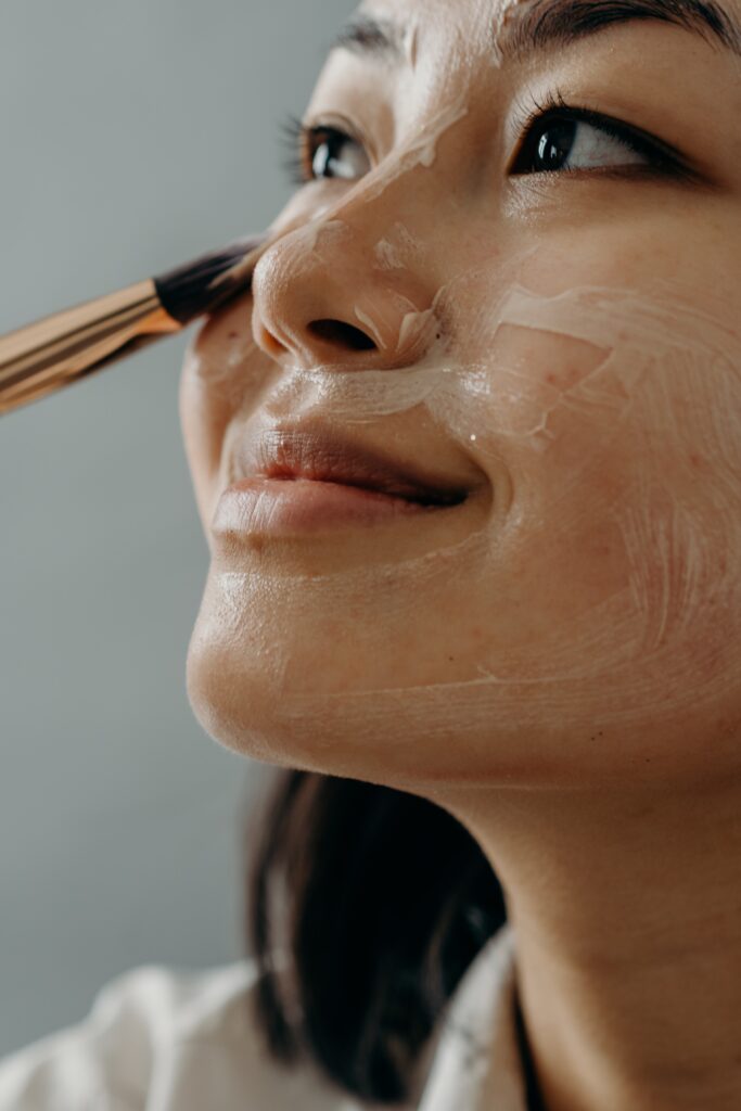 girl applying cream on her face image