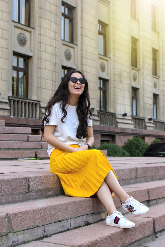 woman wearing a white shirt and yellow skirt sitting image