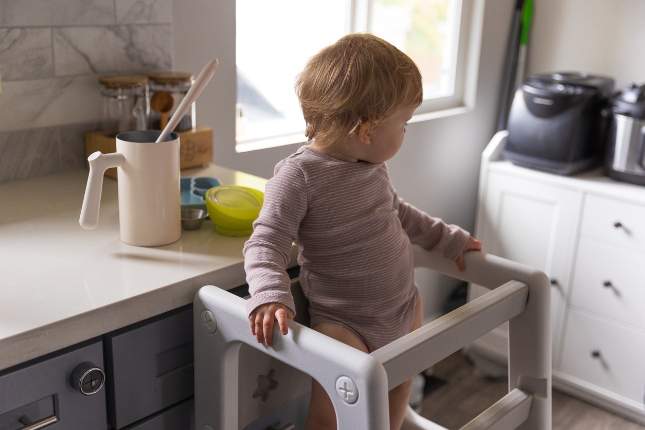 Toddler playing in the kitchen with household objects