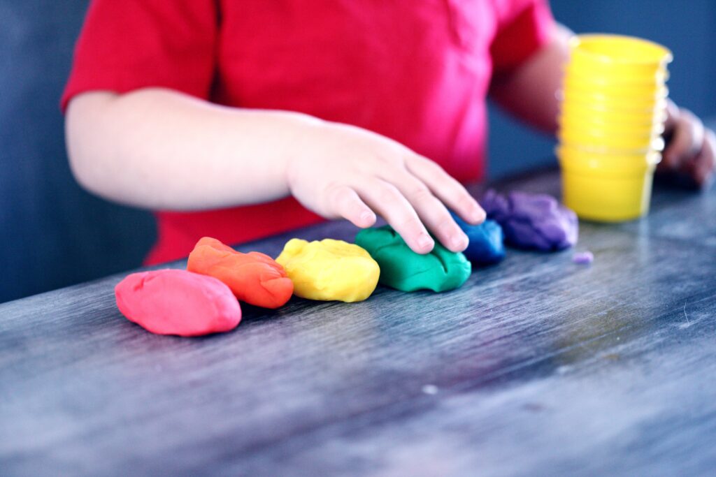 A child playing with colorful dough image