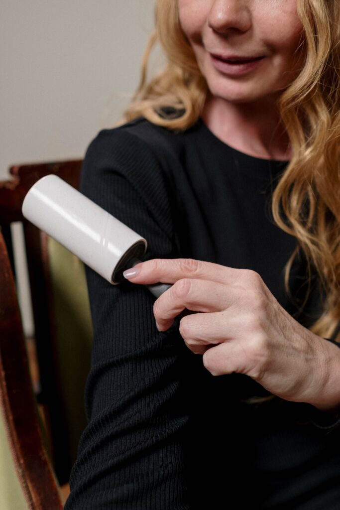 A woman cleaning herself with a lint roller image
