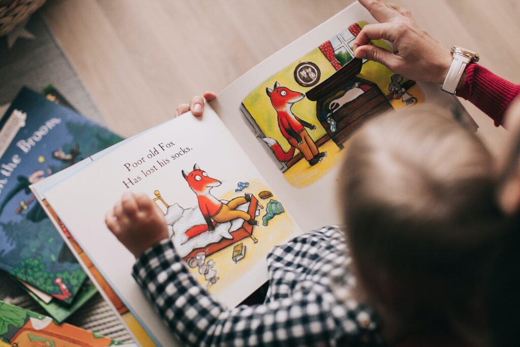 A woman reading a book to a toddler image
