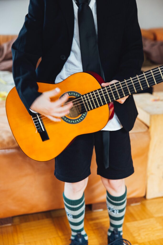 a child wearing a suit while holding a guitar image