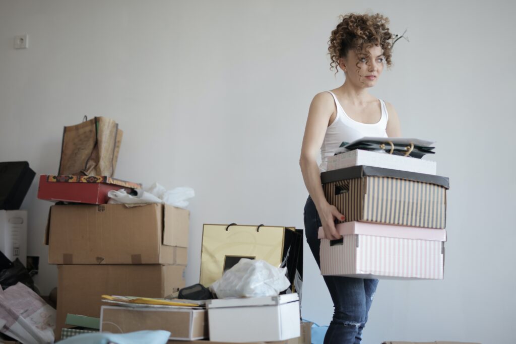 woman carrying stack of cardboard boxes image