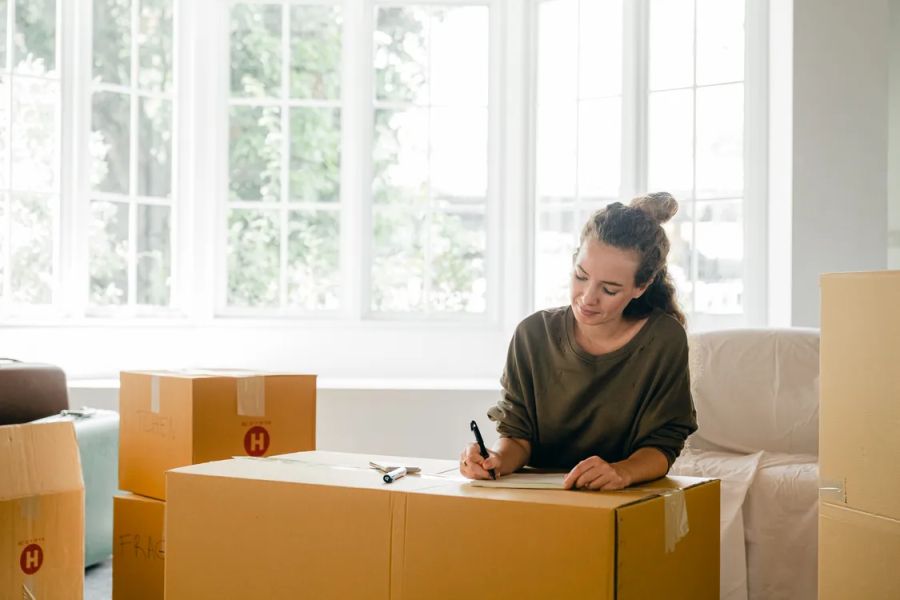 woman writing something on a big box