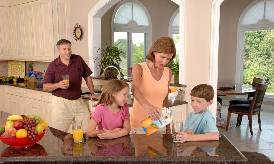 A family drinking juice at the kitchen