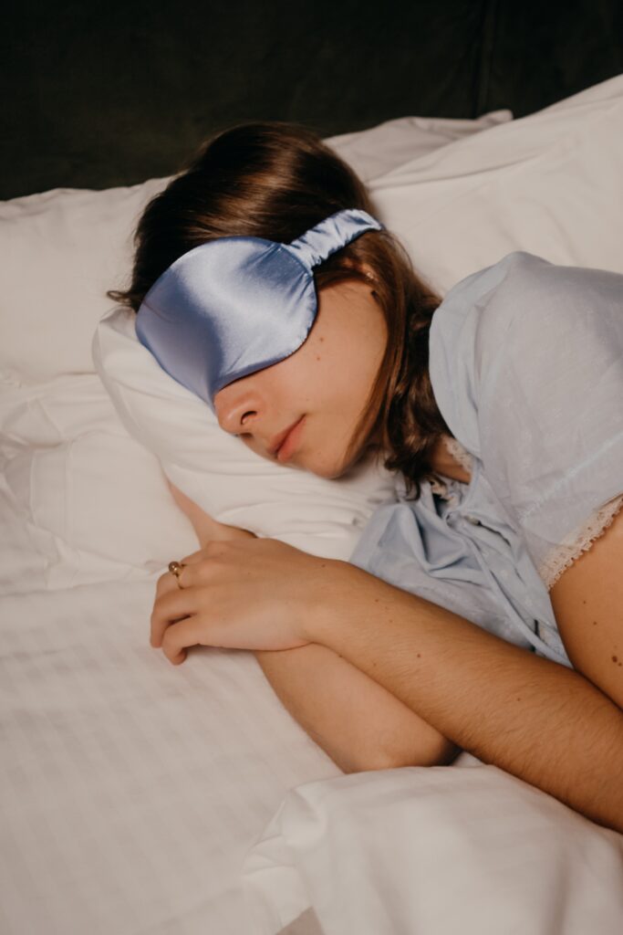 A woman wearing an eye mask and sleeping image