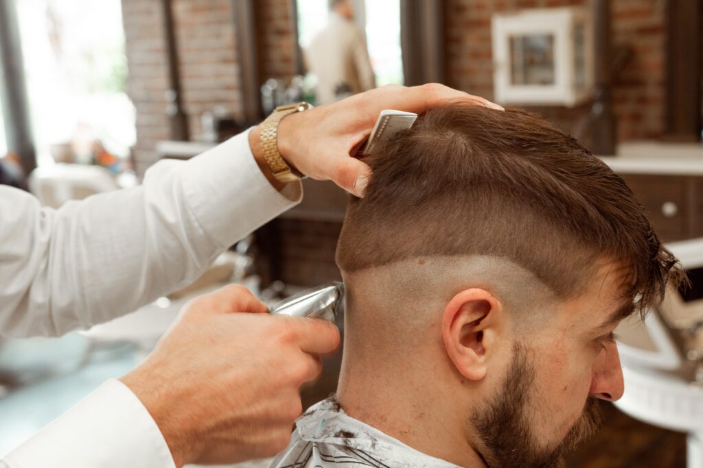 An Image of a  Man getting a buzz cut