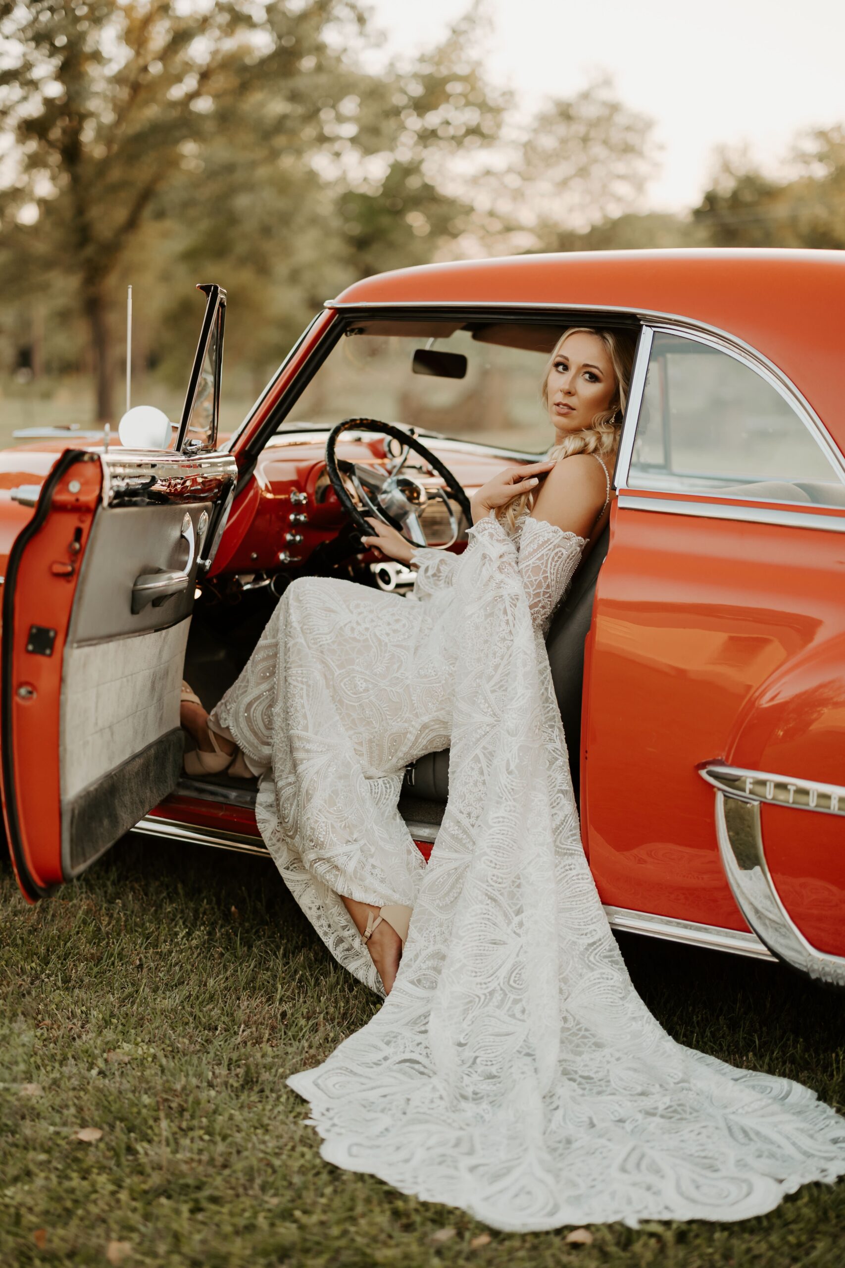 A bride being photographed in a vintage car