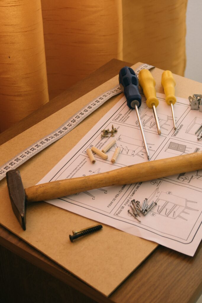 an image of instruction manual, measuring tape and tools