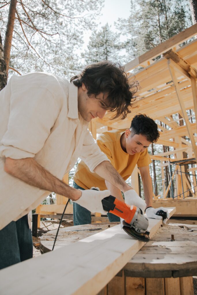 an image of two men working on a wood plank