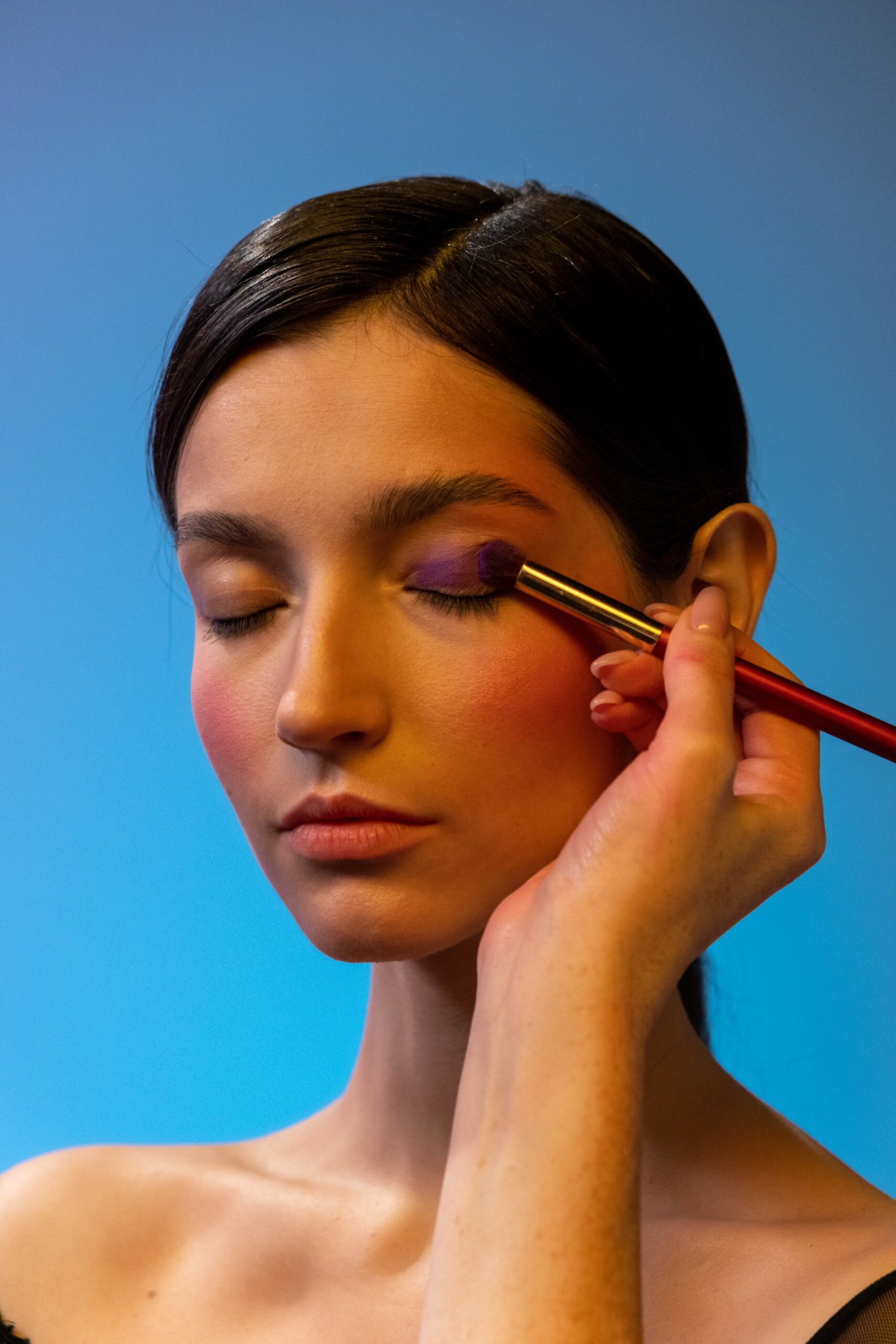 A hand applying makeup on a model image