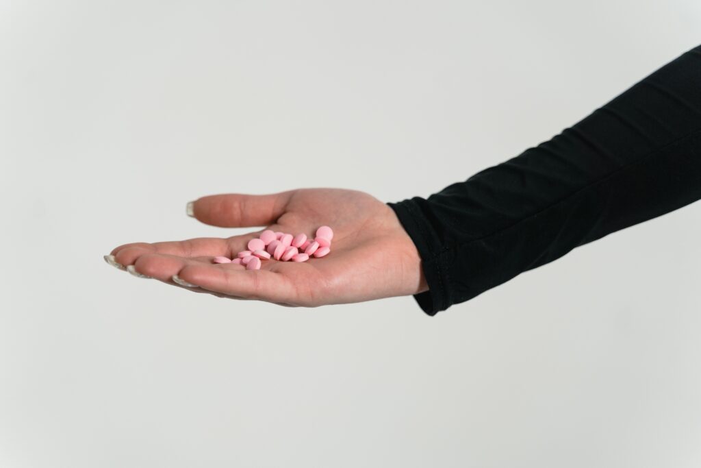 A person with a handful of pills image
