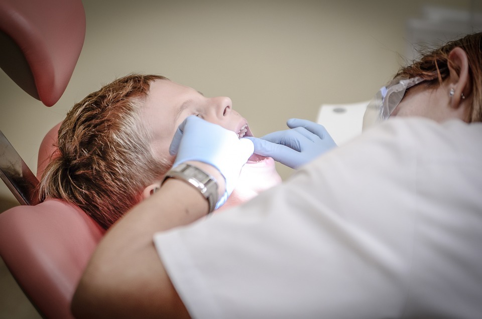 dentist examining a girl’s mouth image