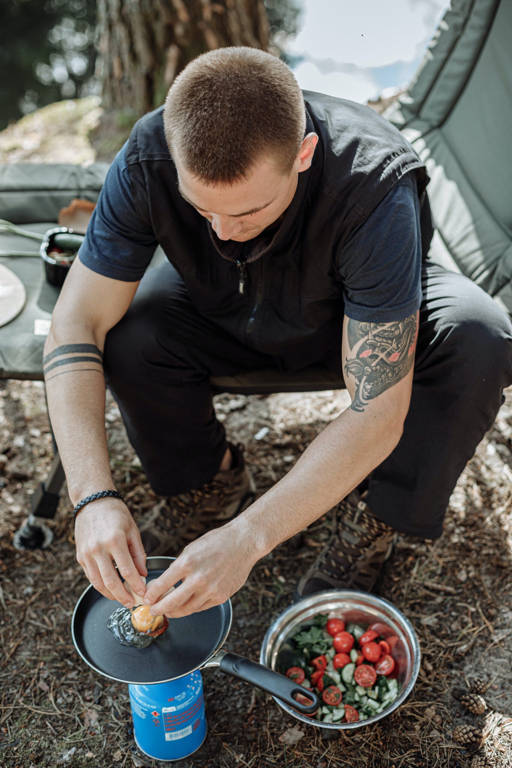 A man cooking an egg while camping image