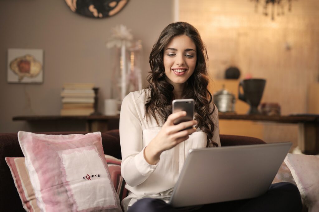 A woman online shopping with her laptop and her phone image