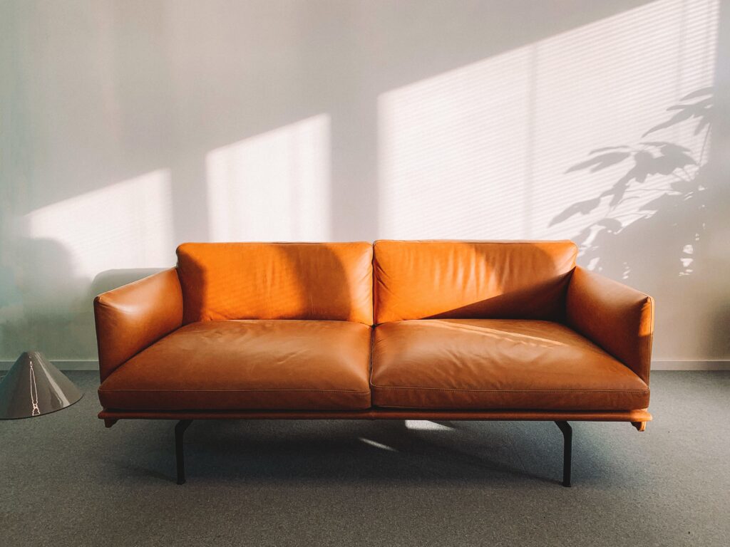 An orange leather sofa against a white wall image