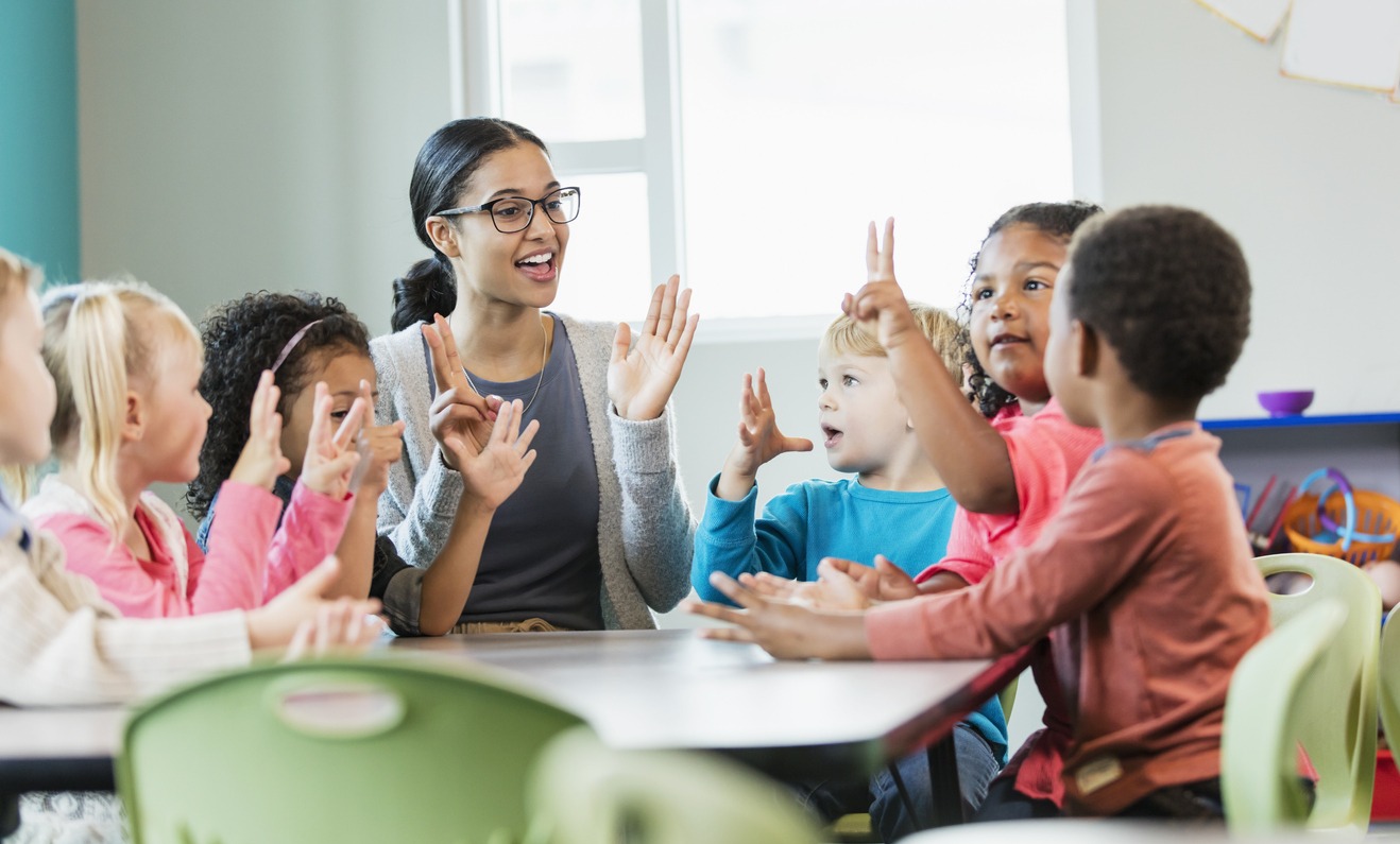 Multi-ethnic preschool teacher and students in classroom