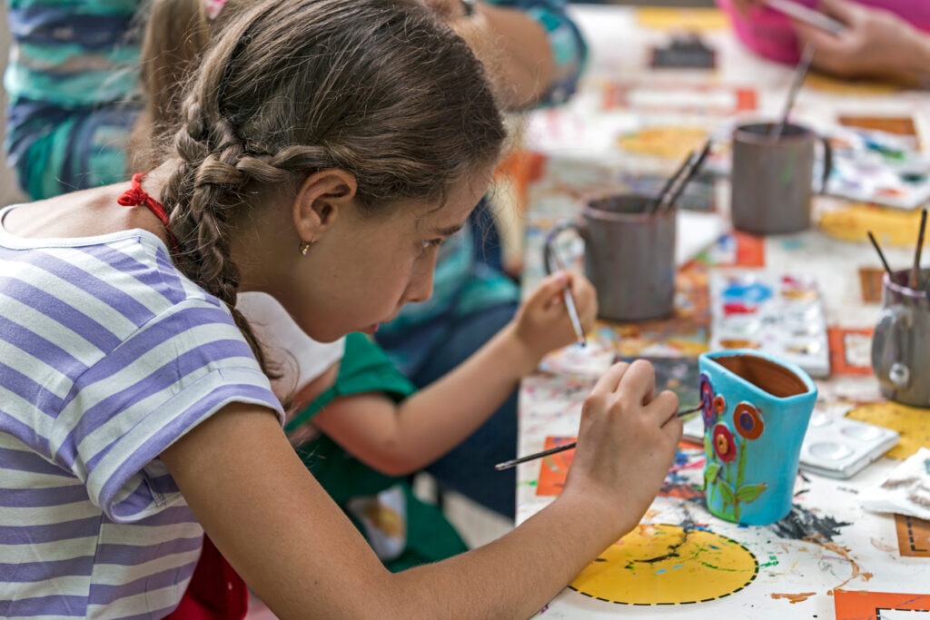 Children painting mugs at a party