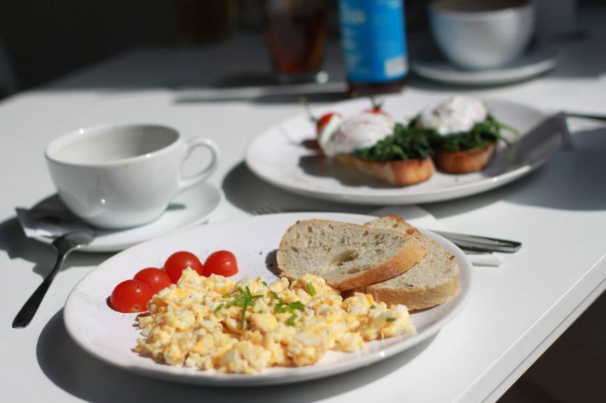scrambled eggs on a plate with slices of bread