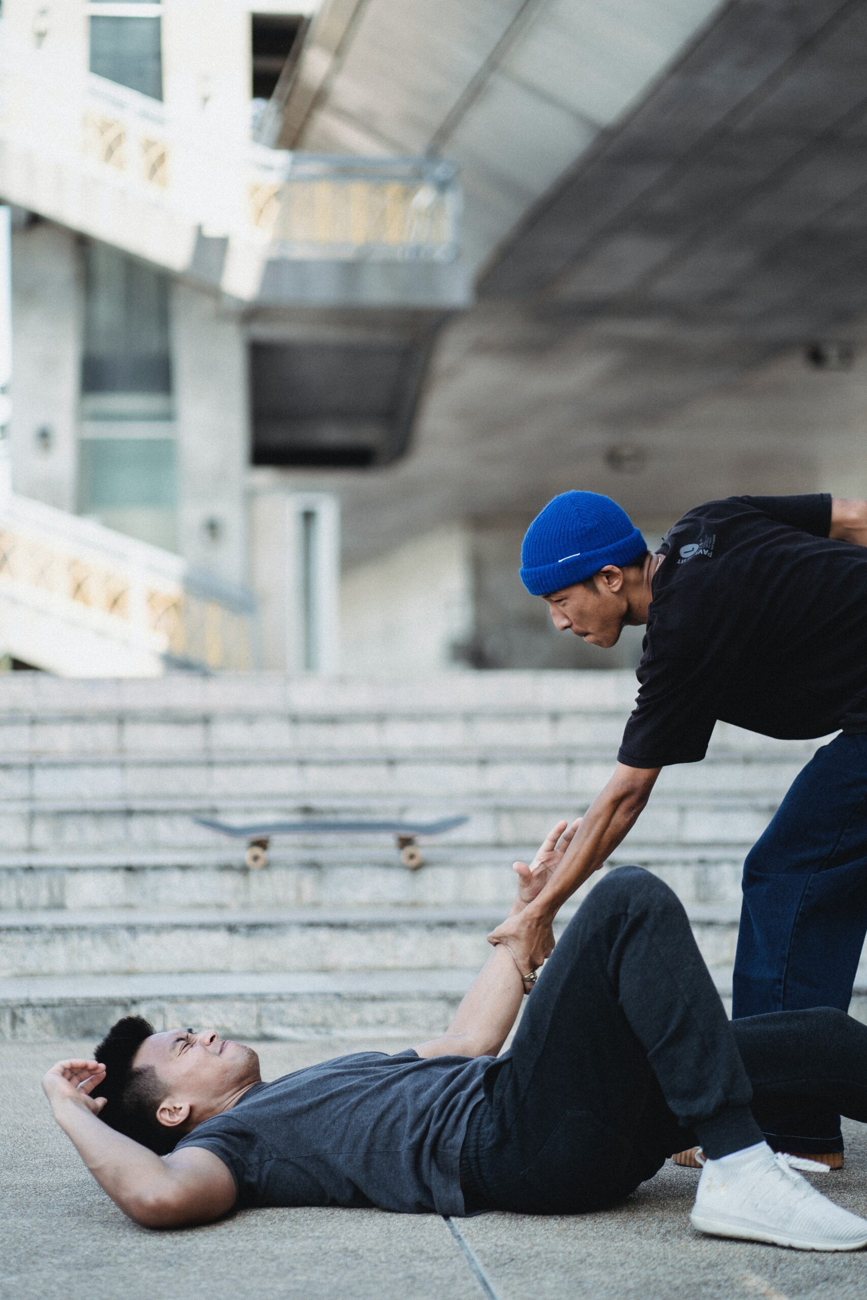 A man helping another person who has fallen on the ground image