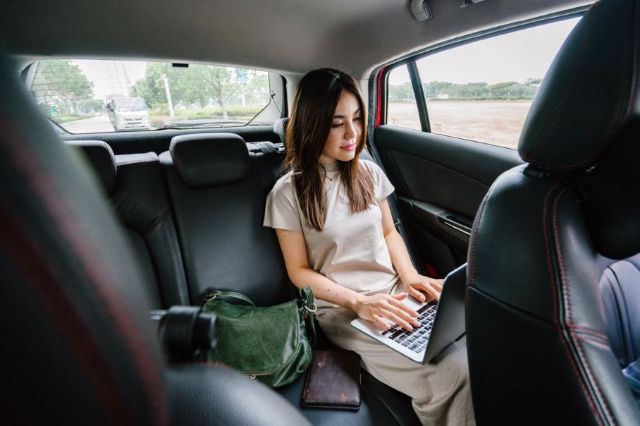a woman using her laptop in a car