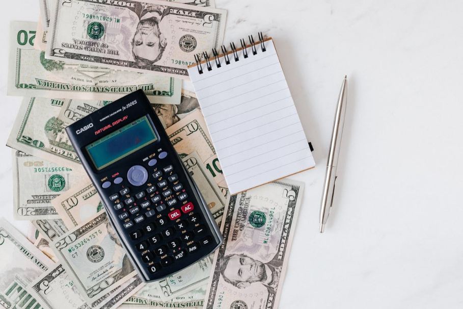 calculator and notepad on money bills