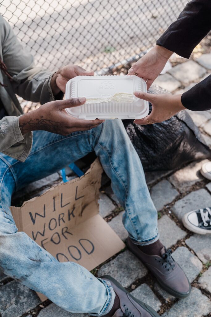 A man giving food to a homeless person 