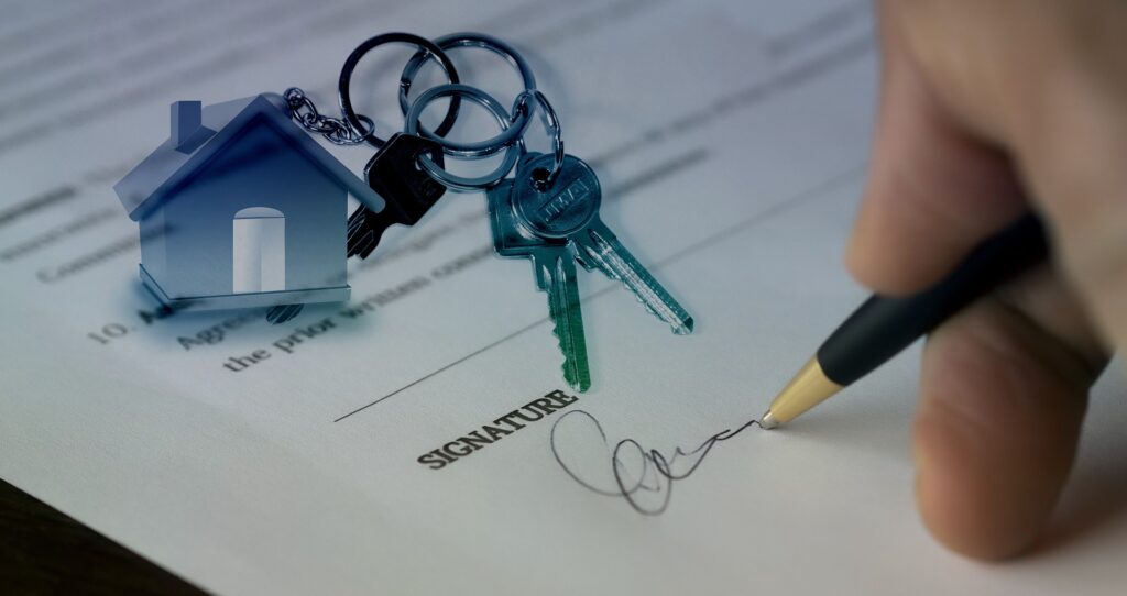 an image of a man signing a contract with house keys