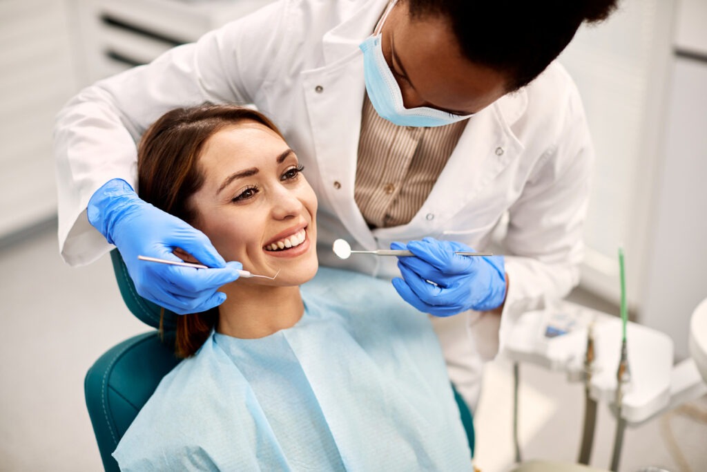a woman smiling during dental procedure at dentist’s office