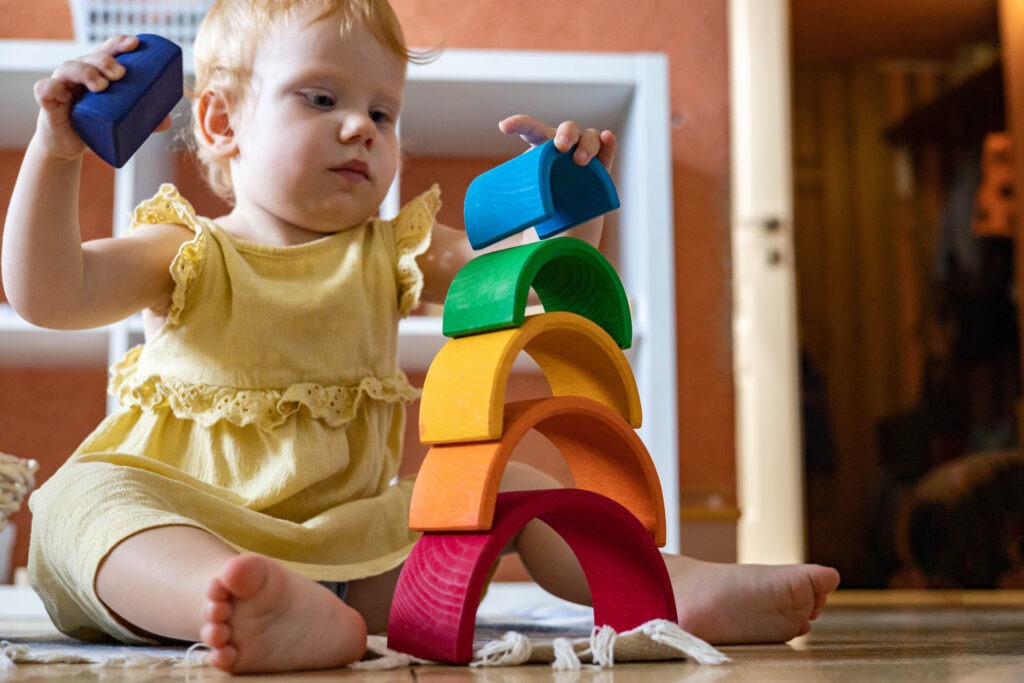 girl-in-dress-stacking-rainbow-arch-block-construction-building image
