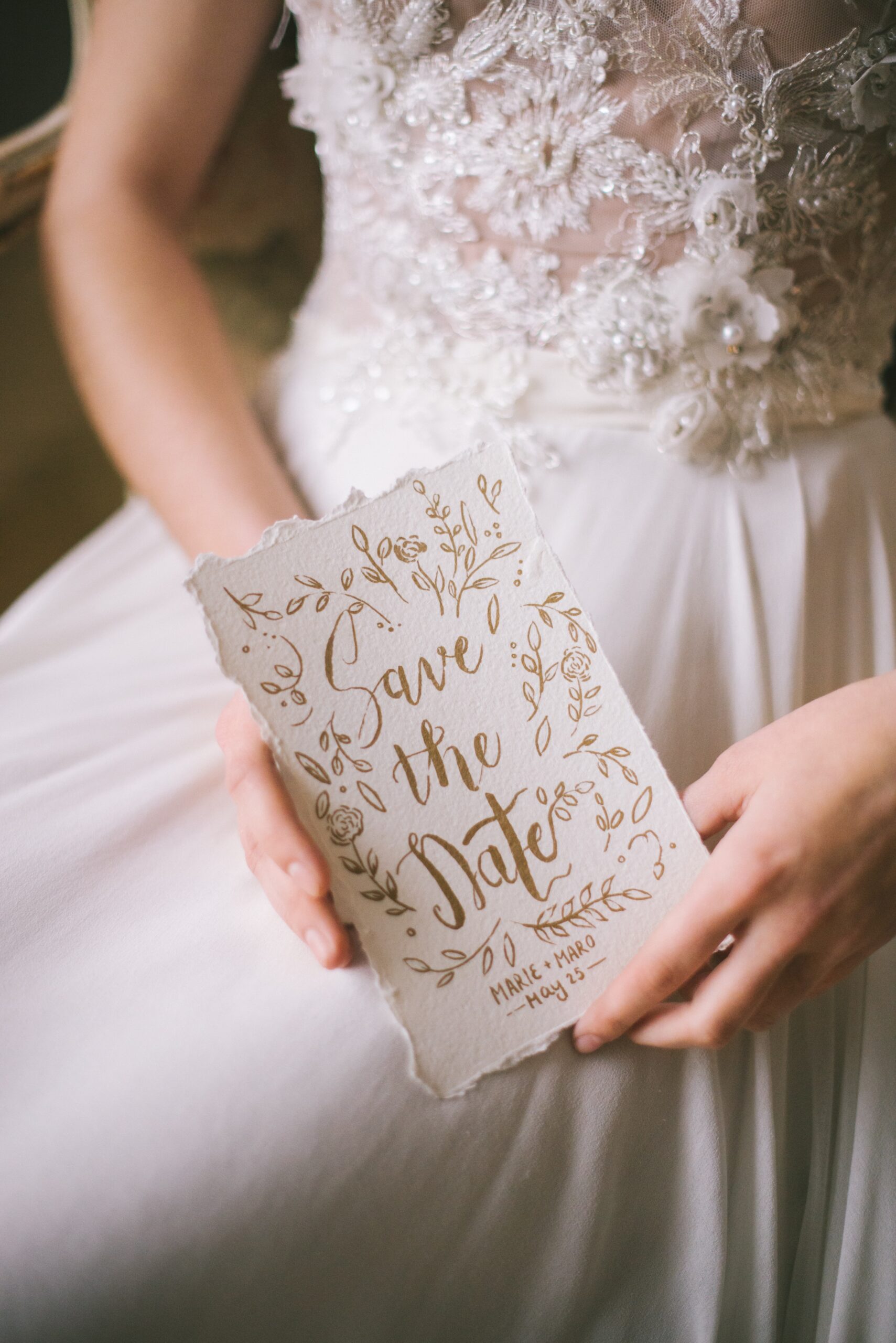 A woman holding a save-the-date invite