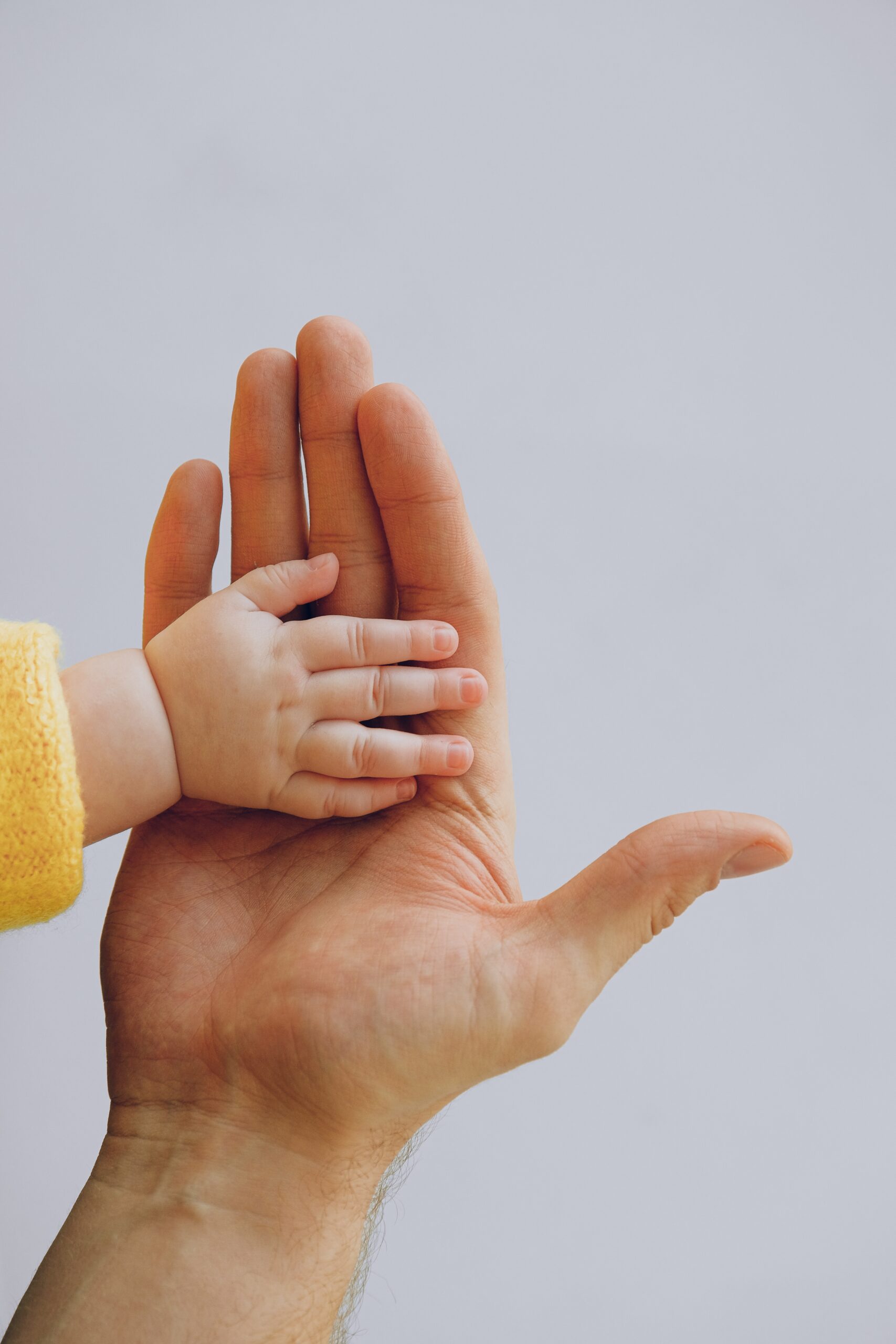 A baby’s hand on another person’s hand image