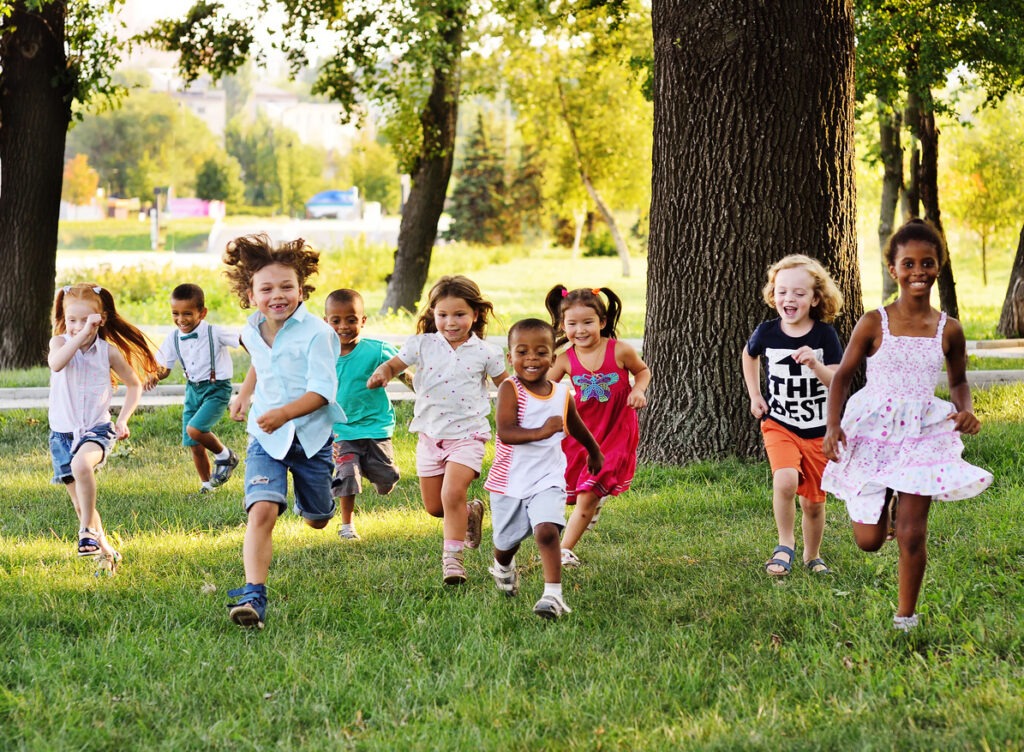 An Image of A group of preschoolers running on the grass