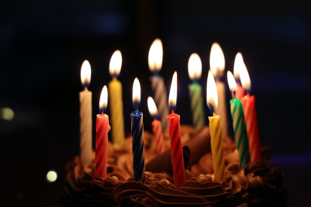 lighted candles on brown cake image